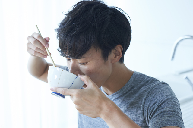 ご飯をかき込む男性